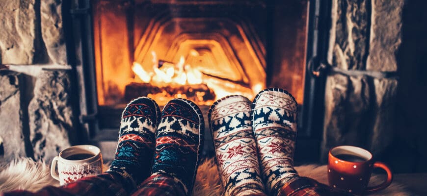Feet,In,Woollen,Socks,By,The,Christmas,Fireplace.,Couple,Sitting